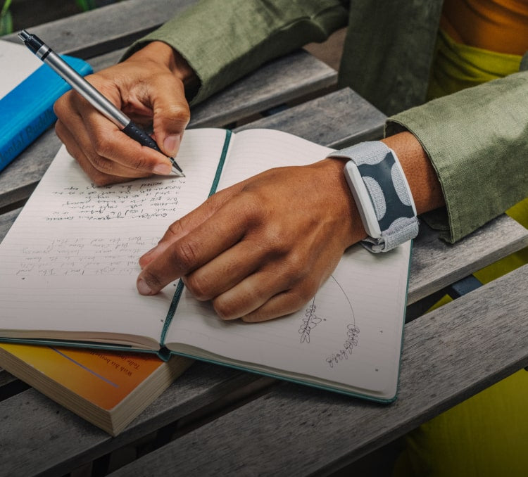 Man wearing Apollo on his wrist while journaling