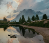 Beautiful imagery of an alpine lake with the reflection of a mountain and pine trees