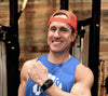 Don Saladino in a blue tank top with a red backwards trucker hat. he has an apollo wearable in black on his left wrist.
