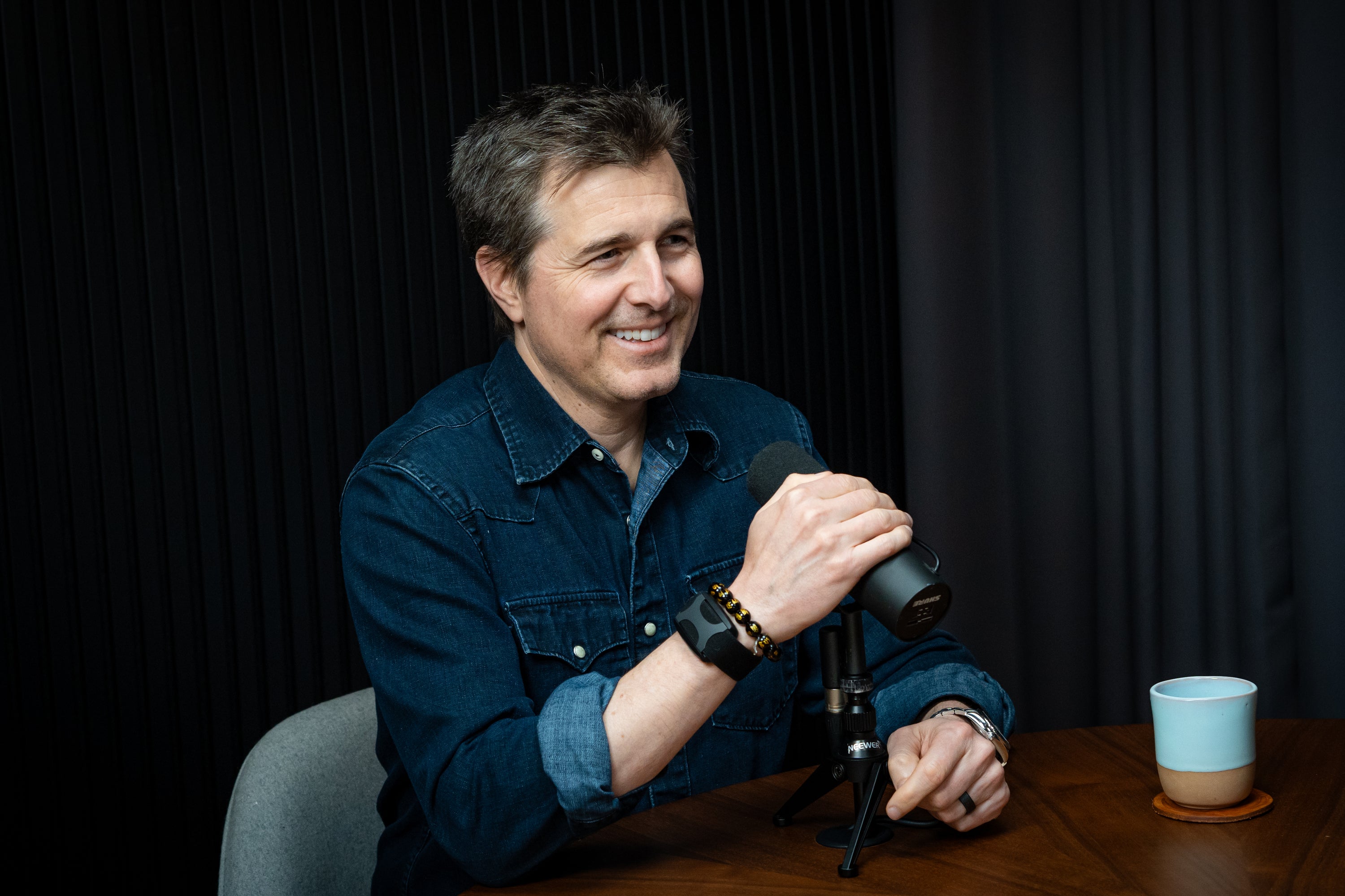 Dr Michael Gervais wearing an Apollo wearable with a microphone in his right hand
