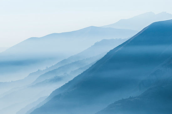 Cloud covered mountains with a blue filter
