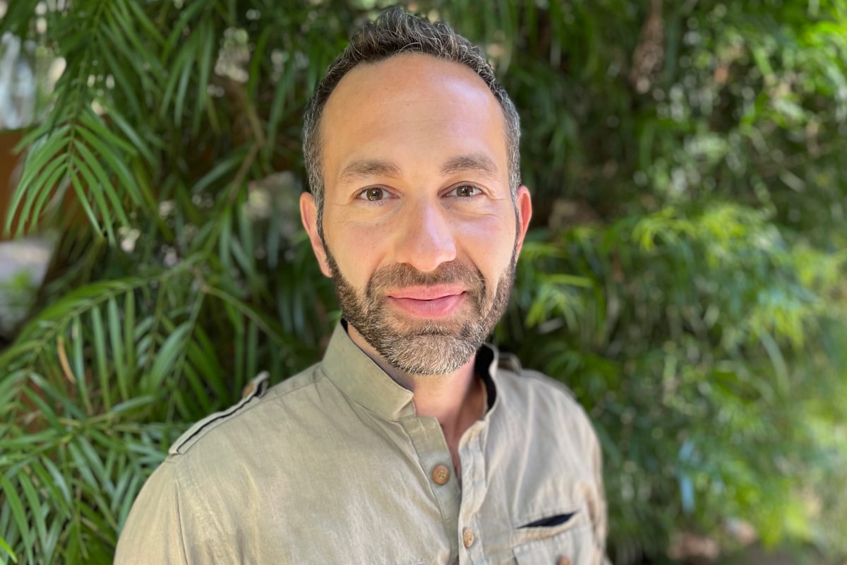 Alan C. headshot in front of greenery
