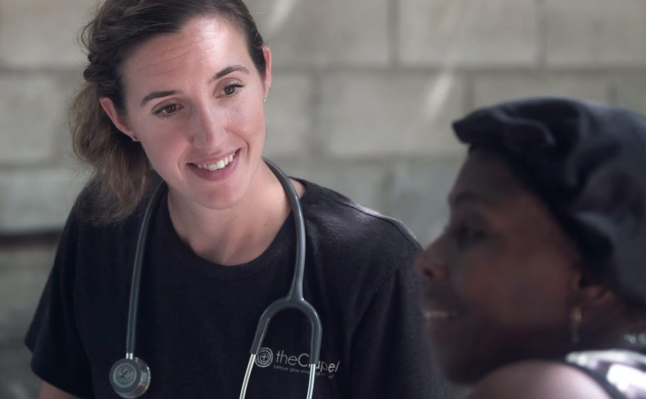 Nurse wearing a stethoscope talking to a patient