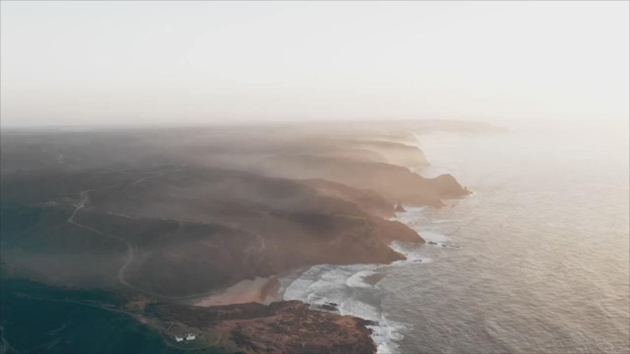 Load video: video cover image of a ocean waves hitting coastline from high up view