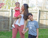 A brown-haired woman holding hands with her son and daughter outside. She's wearing a Glacier Apollo on her wrist.