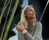 A relaxed woman sitting outside with a Rose Apollo on her wrist